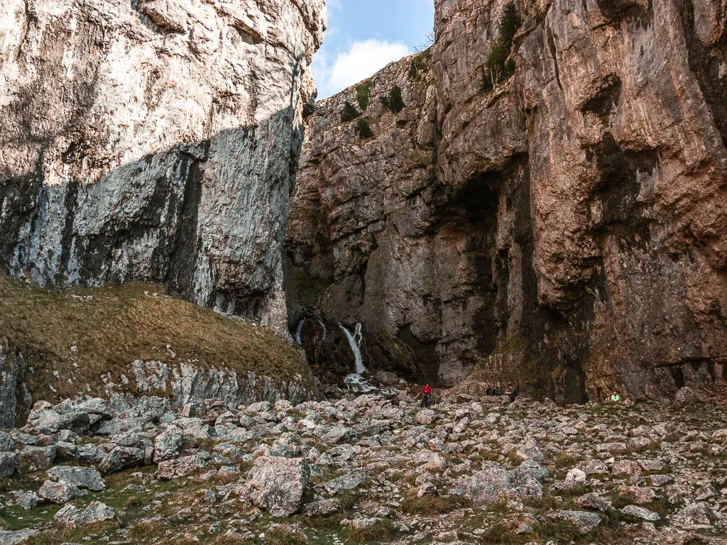 Looking into the gorge of the impressive Gordale Scar with a waterfall running down it, on the circular walk to Malham Cove.