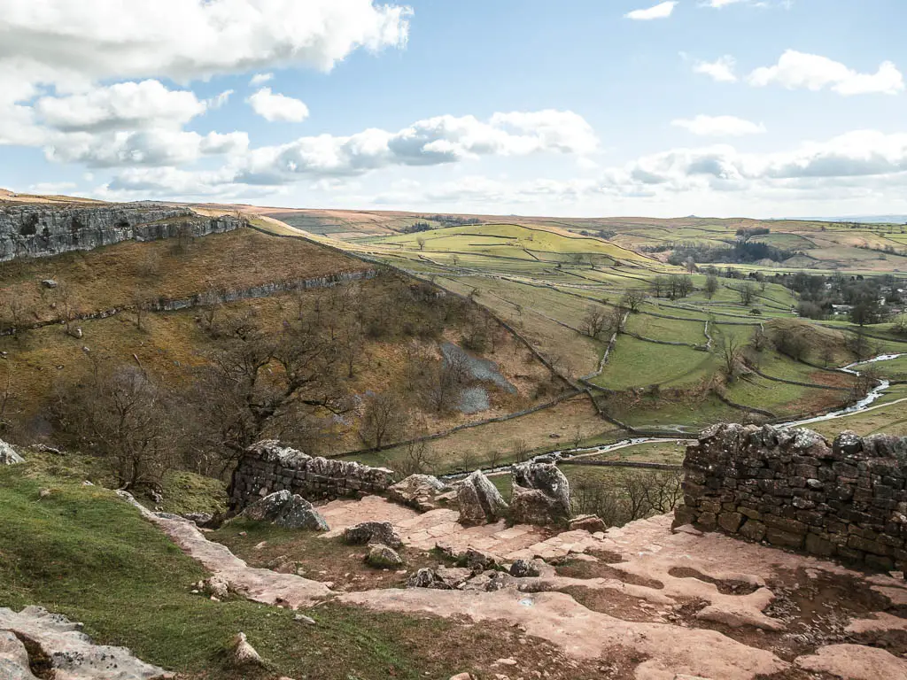 Stone steps, leading downhill with Malham Cove to the left and the valley below.