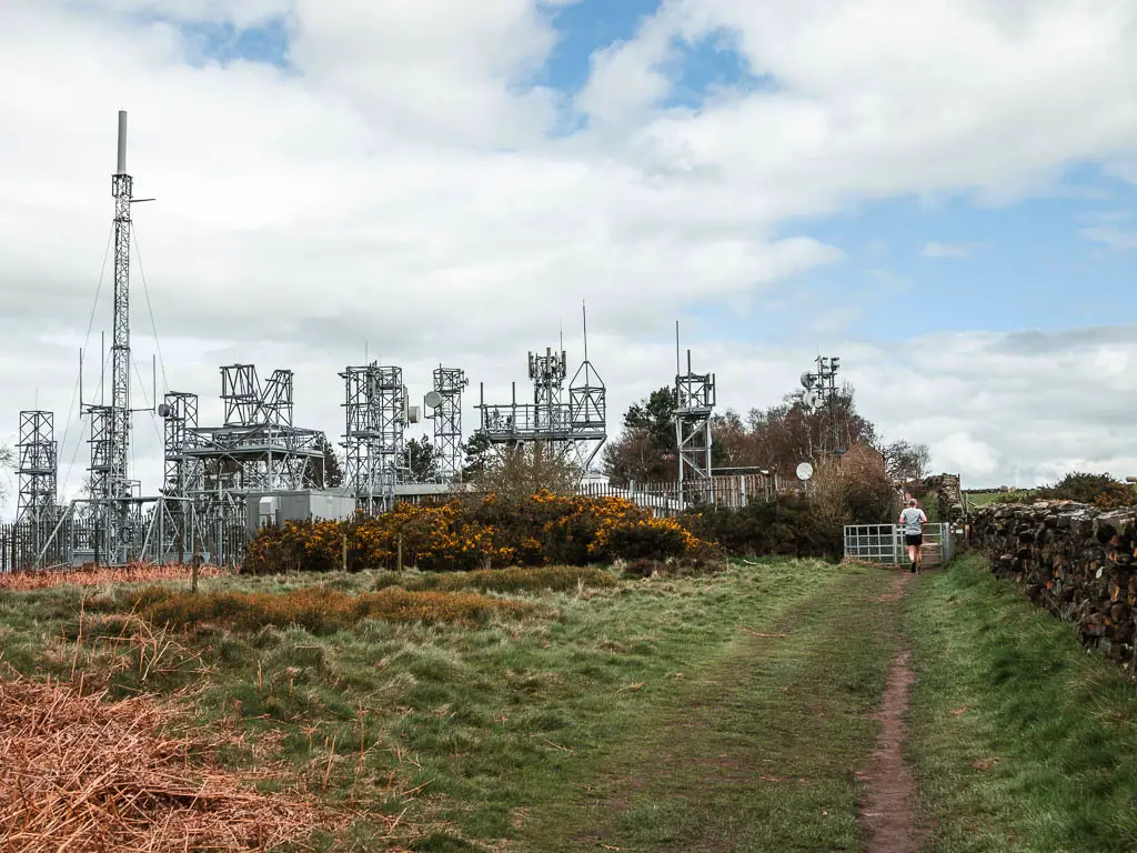 A grass path on the right and a metal structure ahead to the left.