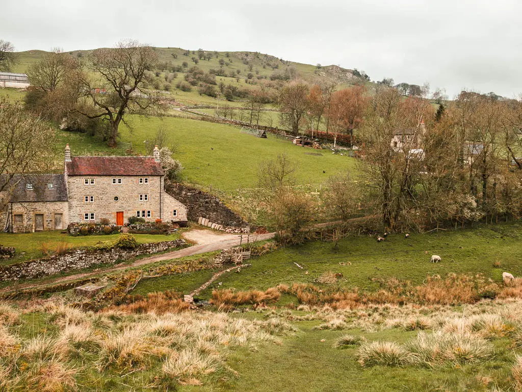 Looking down the hill to a cottage in the valley below, near the end of the Thor's Cave circular walk.