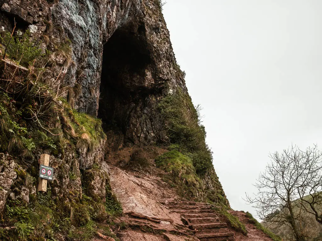 Looking up at the entrance to Thor's Cave, with rock steps to walk into it.