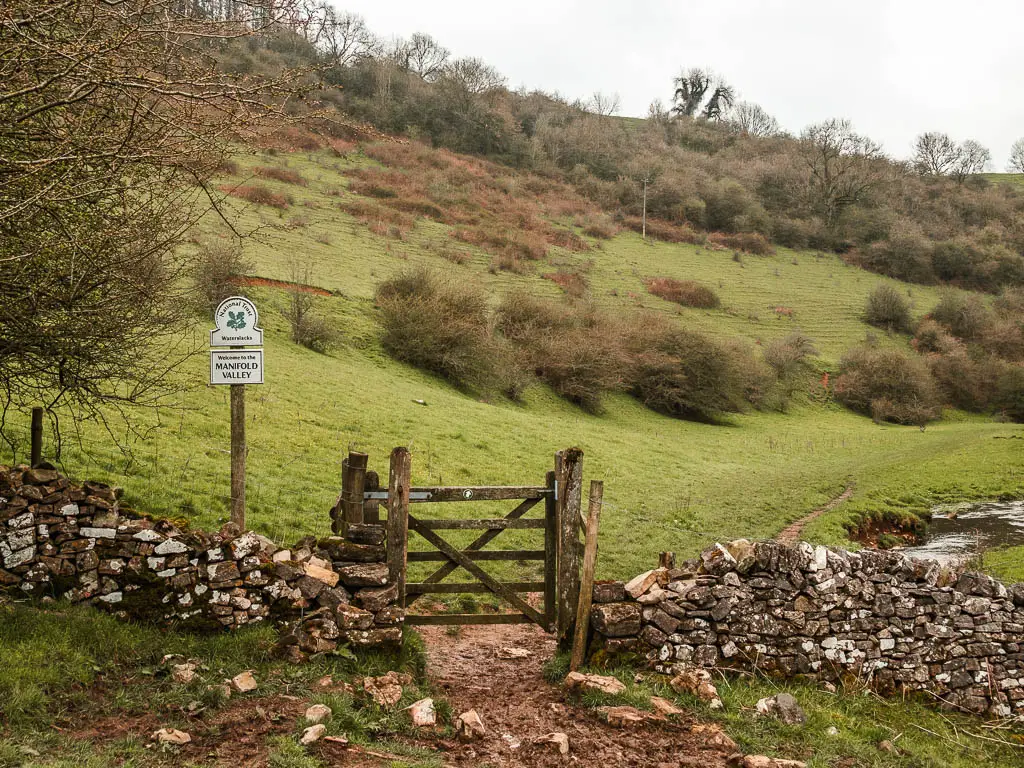 A wooden gate in a stone wall, with a sign saying 'Manifold Valley', halfway through the circular Thor's Cave walk.