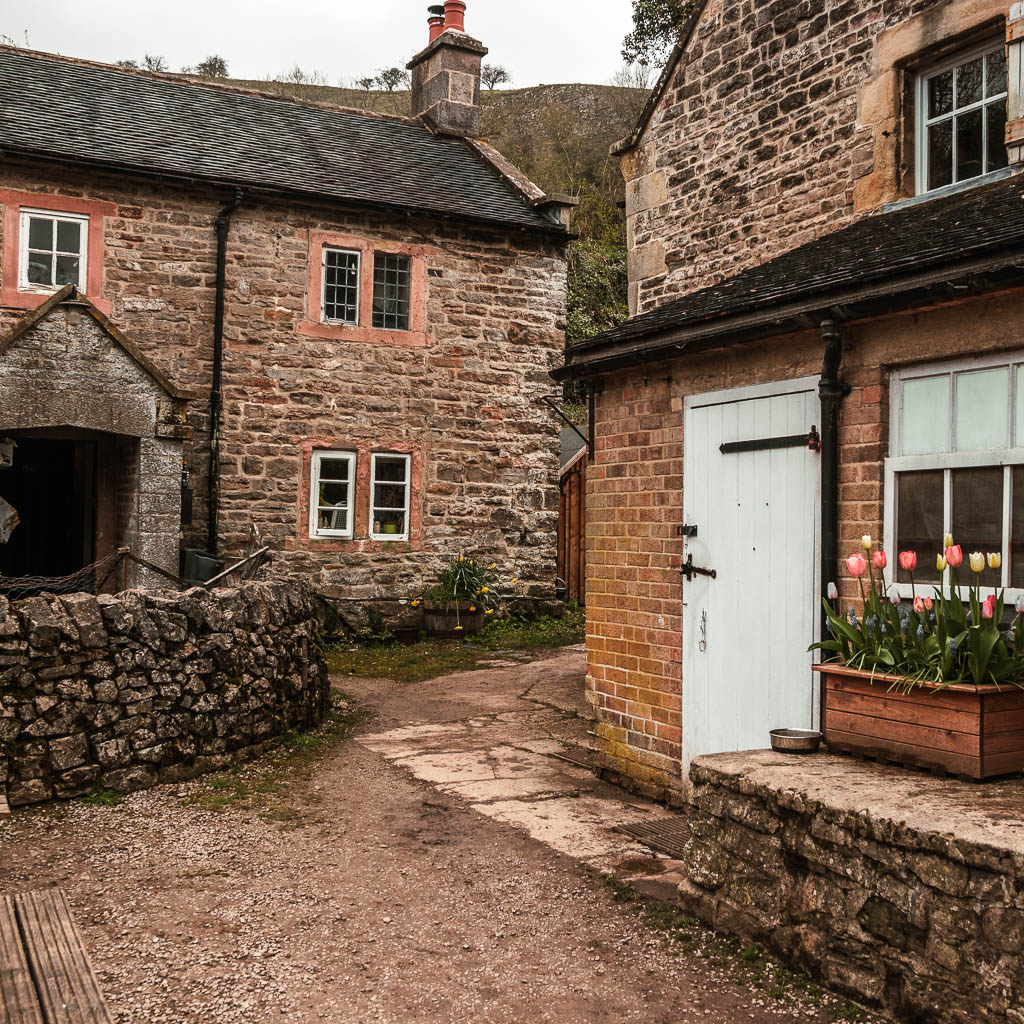 The path leading through a gap in the brick and stone walled houses. 