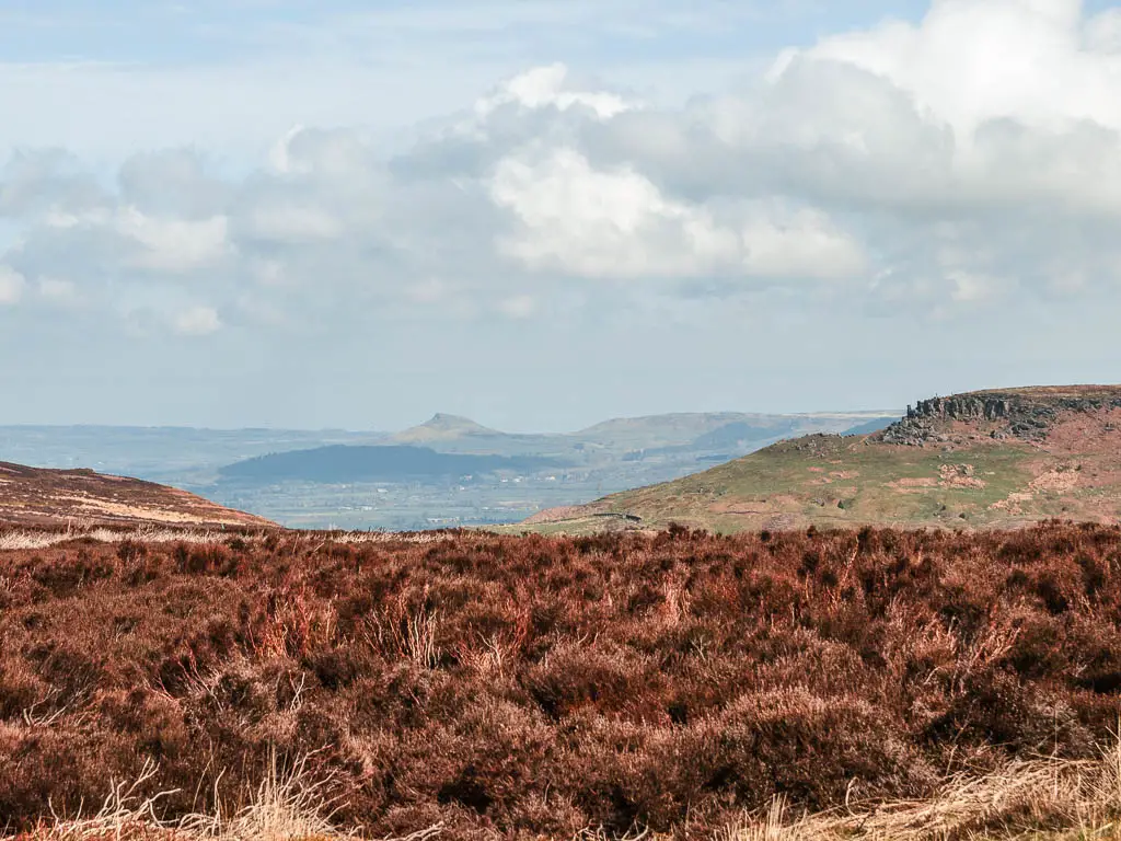 Looking acorns the heather to the vast view beyond, with a view to Roseberry Topping in the distance, and the Wainstones to the right, way ahead.