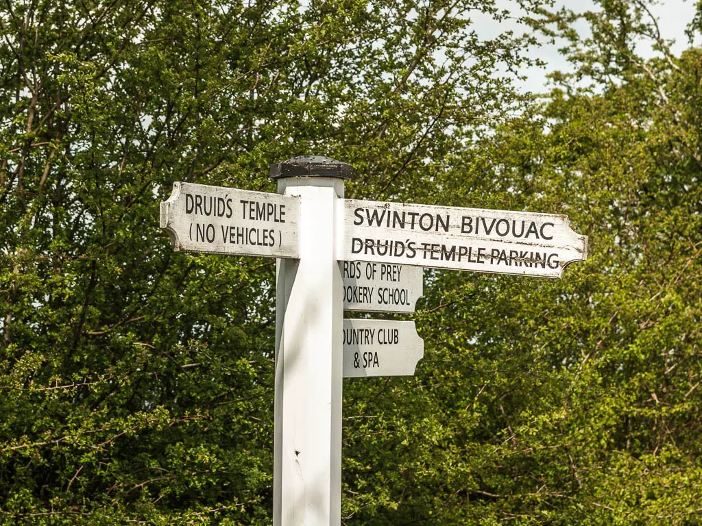 A white signpost pointing left for Druid's Temple, and right for Swinton Bivouac, at the end of the walk.