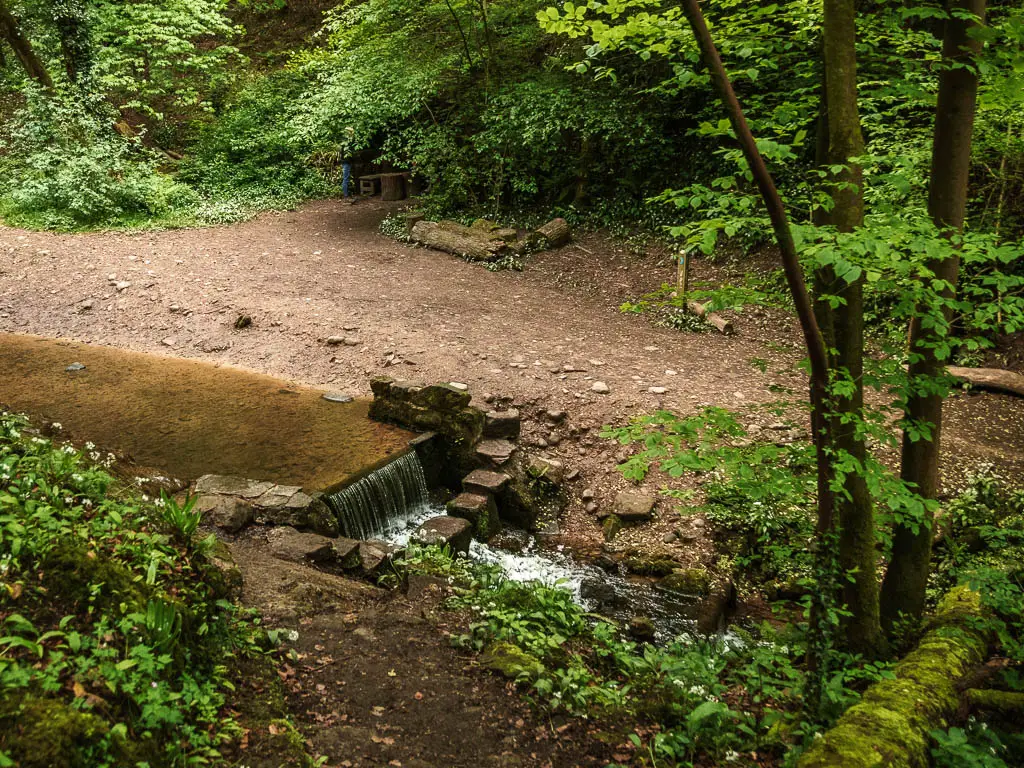 Looking down to a stream of water and small waterfall.