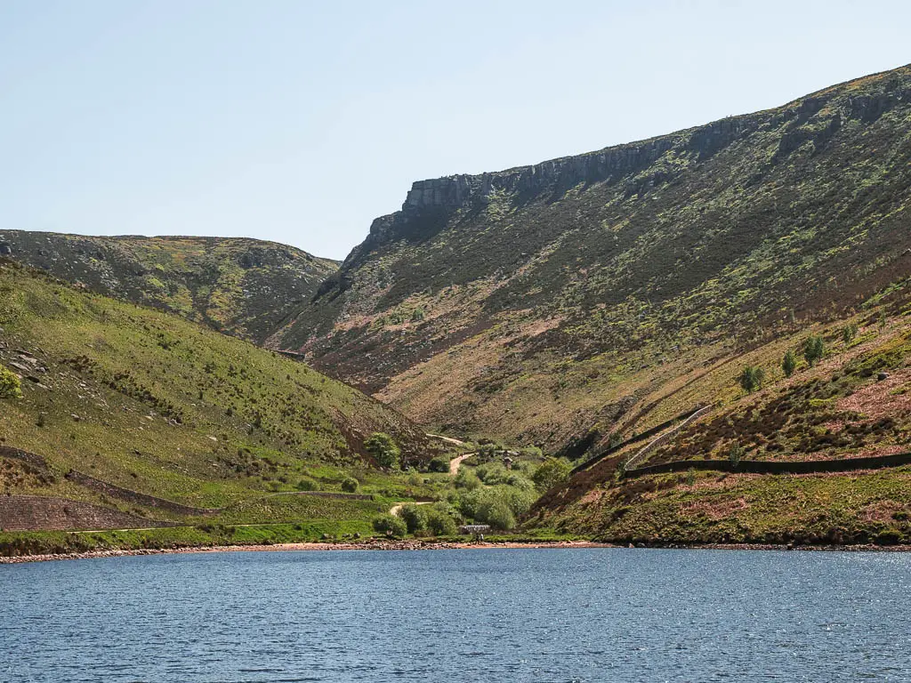 Looking across the reservoir, towards a trail running through a gap in the valley on the other side, and the Trinnacle on top of the hill above it.