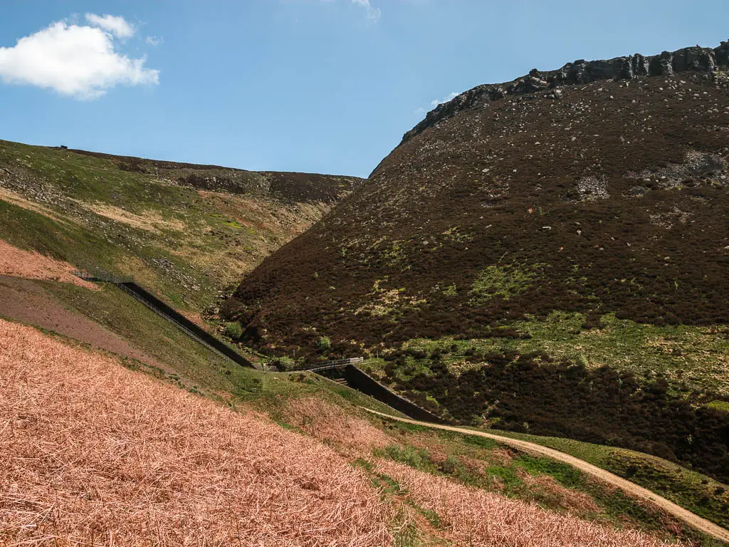 Looking down towards a bridge in the middle of a dip in the valley.