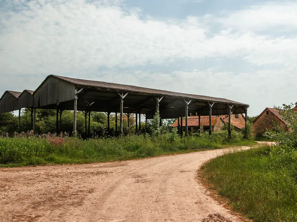 The path as it curves around a farm shelter.