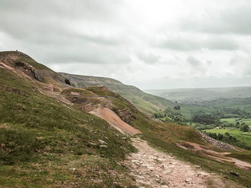 Looking along the undulating hillside, with the valley below to the left, partway through the Fremington Edge walk in the Yorkshire Dales.