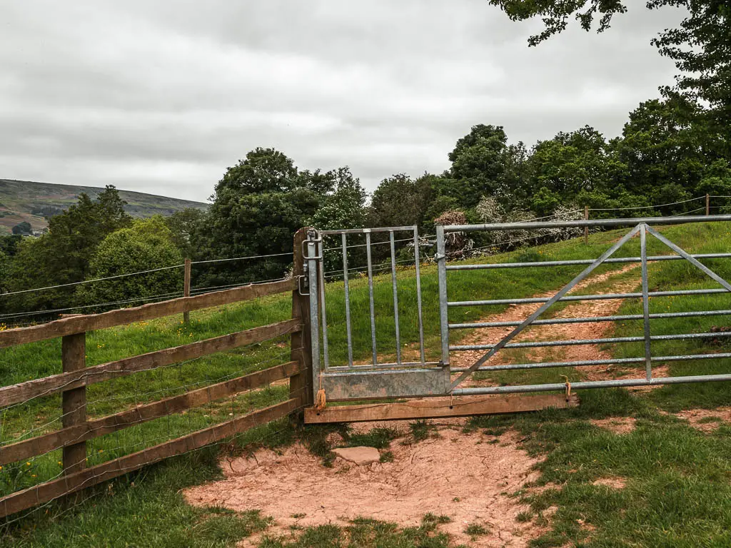 A metal gate in the wooden fence.