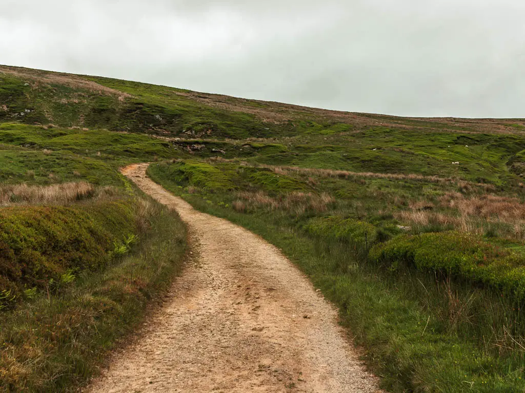 A gravel path winding up the grass hill, on the walk up towards Blakey Ridge.