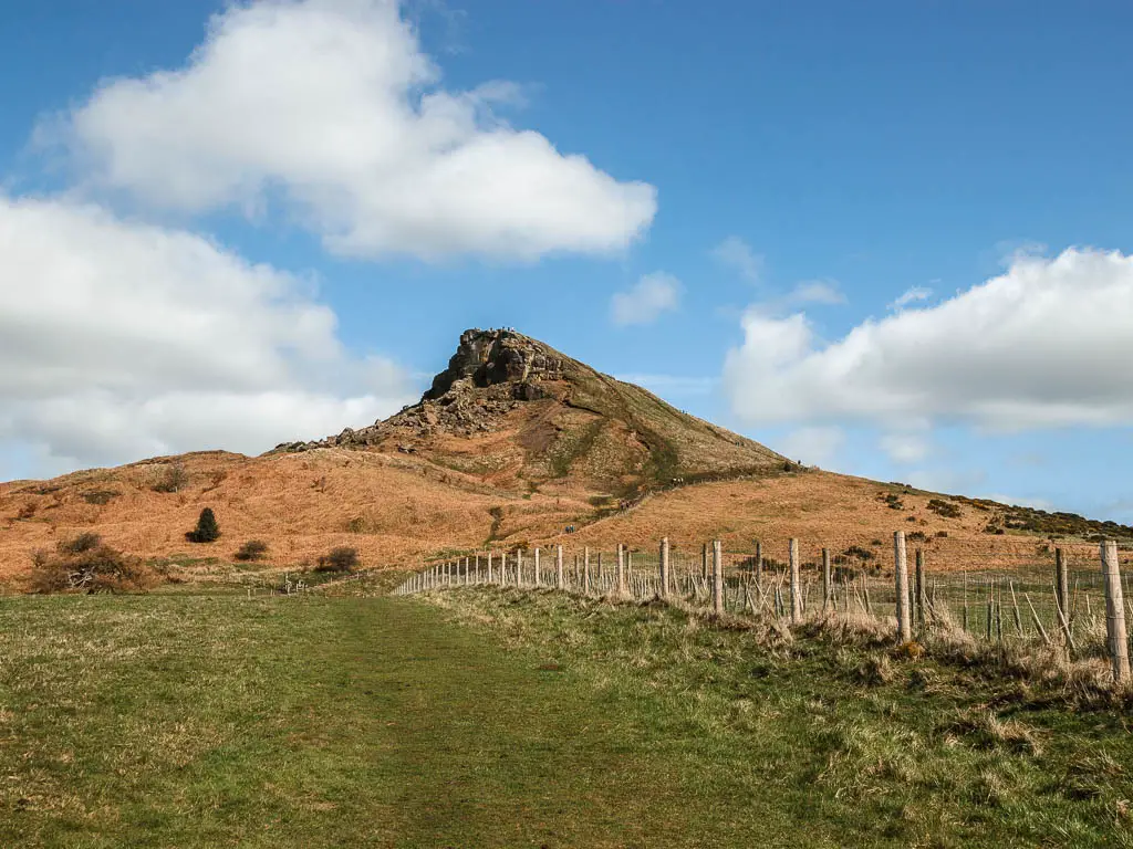 Looking across the green grass to a pointy peak ahead, on one of the best walks in the North York Moors National Park.