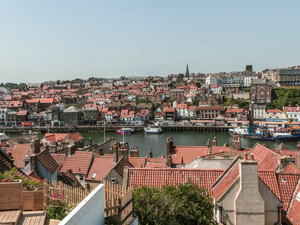 Looking down over the red rooftops of Whitby, with the river Esk running across the frame in the middle, halfway through the circular walk from Robin Hood's Bay.