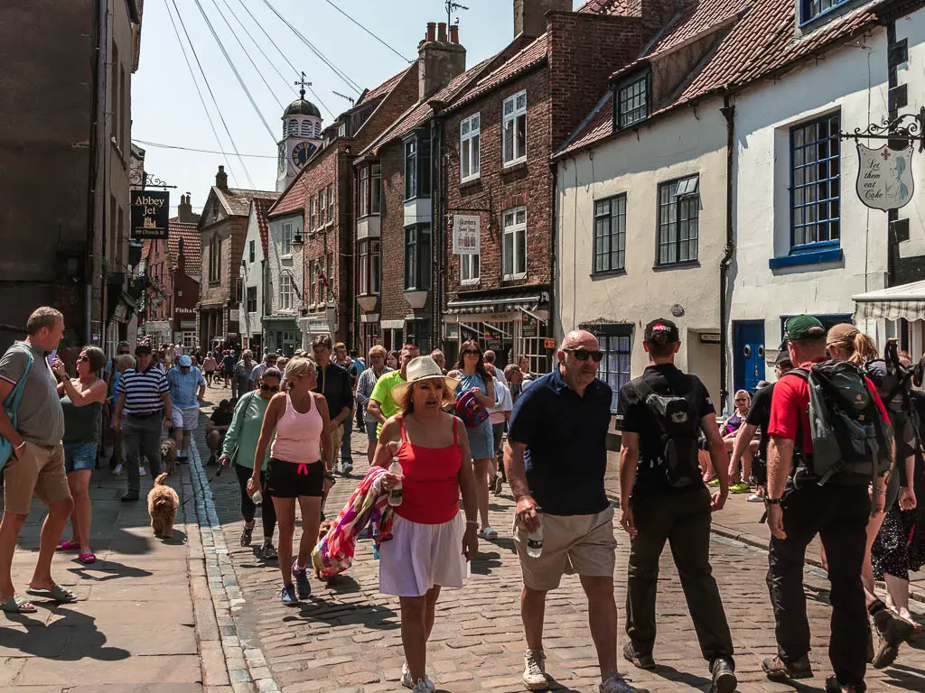 Masses of people walking along a narrow street in Whitby.