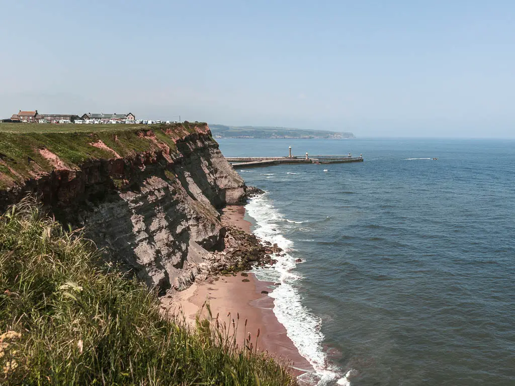 Looking down to a secluded beach, with the rocky cliff rising up on the left, and the sea to the right, near the end of the coastal walk from Robin Hood's Bay to Whitby.