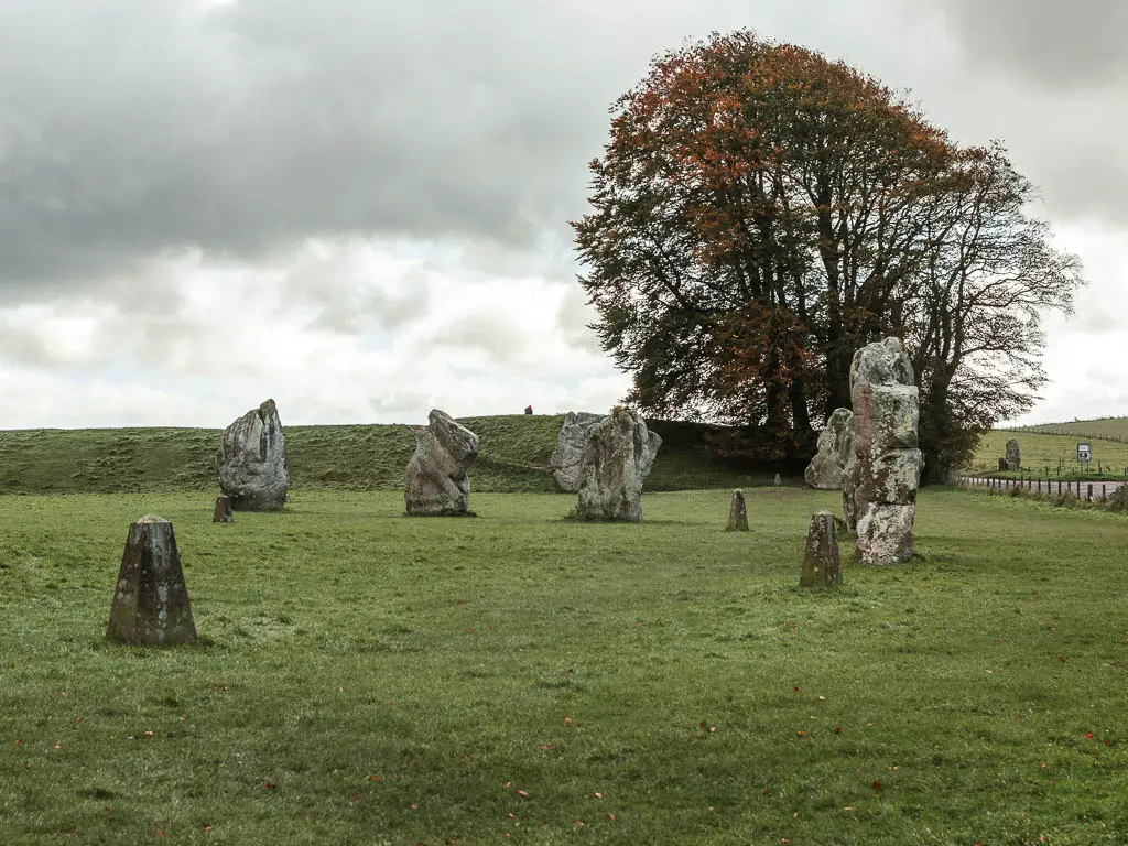 Large stones in a green grass field in Avebury, at the start of the walk to Ogbourne St George.