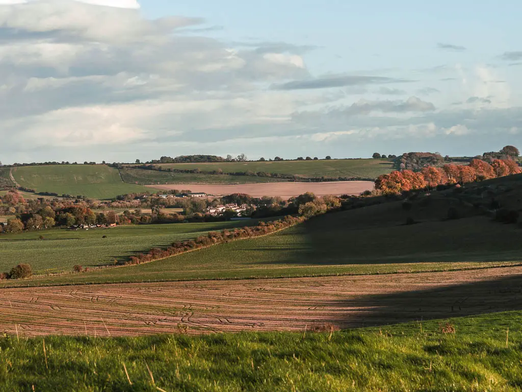 Looking downs across the undulating hill fields to the village of Ogbourne St George below, near the end of the walk from Avebury.