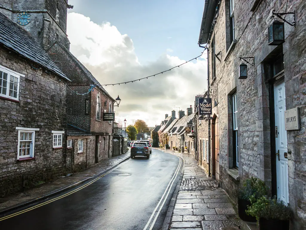 A quiet residential road, lined with quaint stone houses in Corfe Village, at the start of the walk to Ballard Down and Swanage.