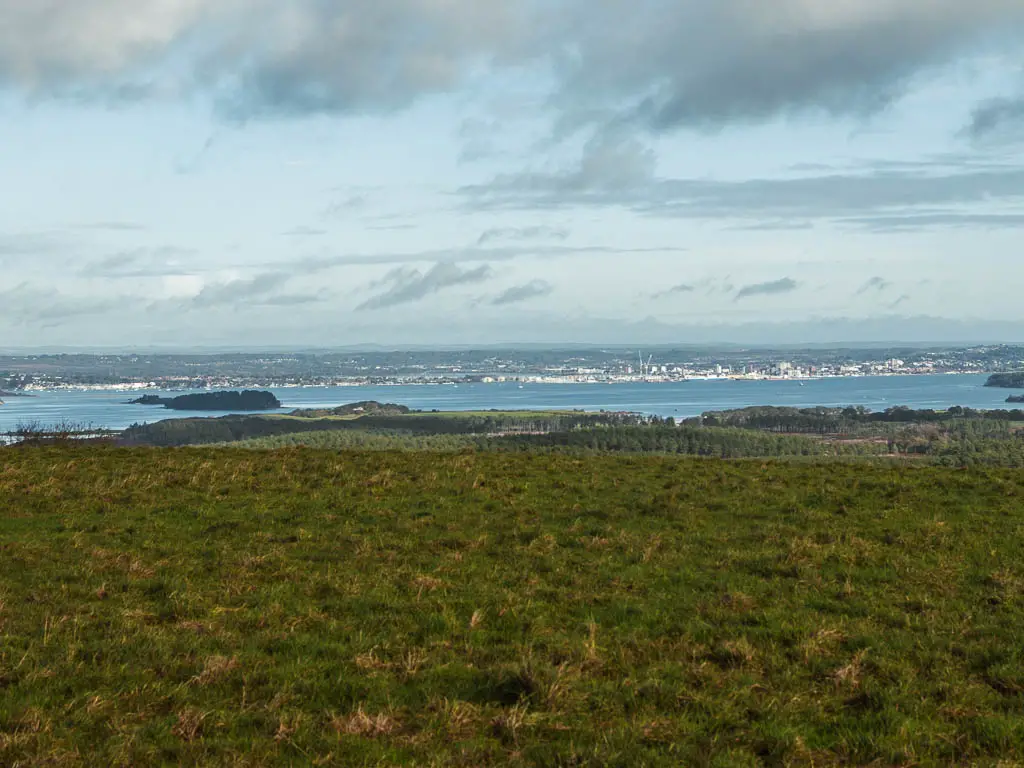 Looking across the grass field with the blue sea below.