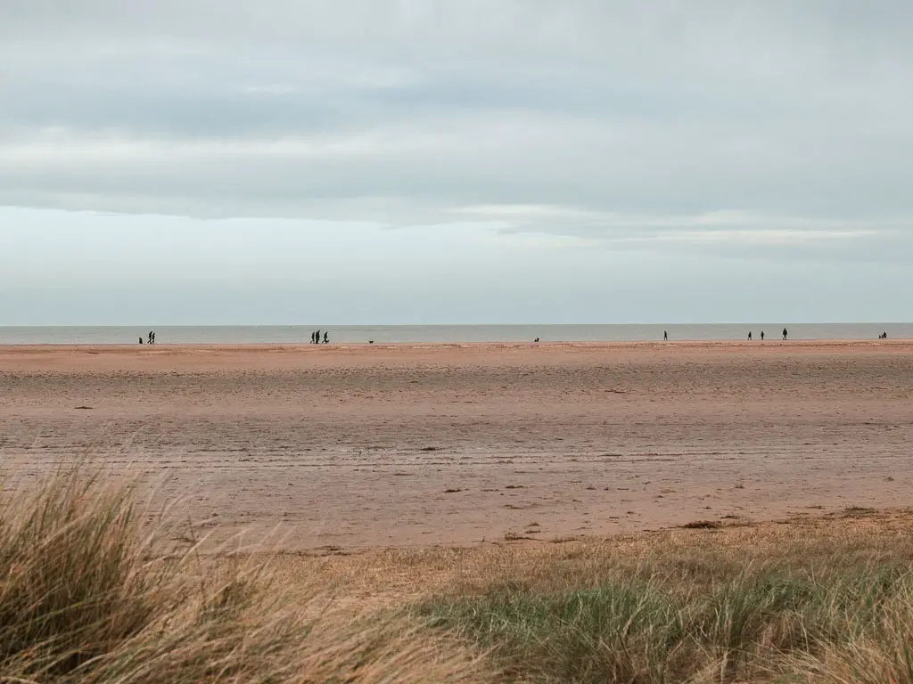 Looking across the wide flat sandy beach towards the sea, near the start of the walk from Burnham Overy Staithe to Blakeney.