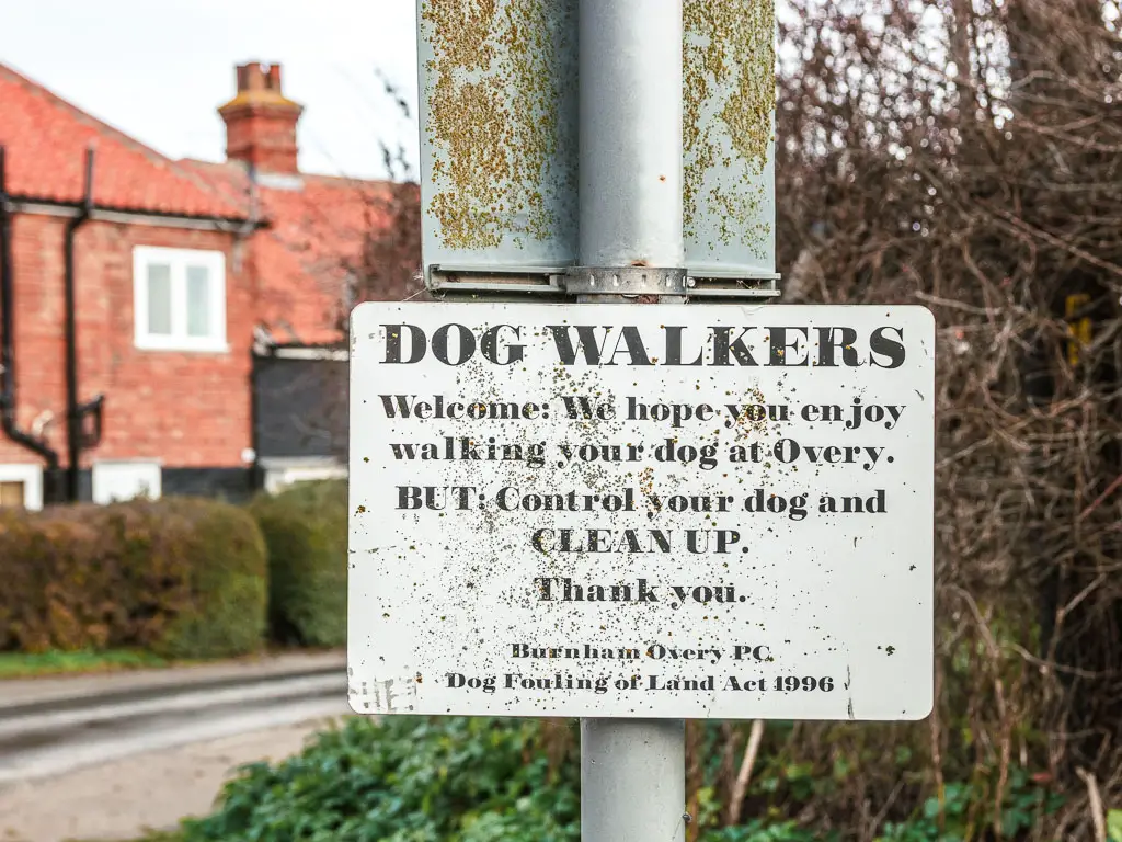 A sign on a pole saying dog walkers are welcome.