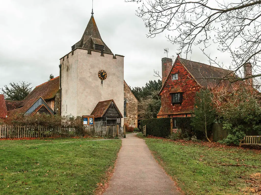 A path leading through the neatly cut grass towards a church.