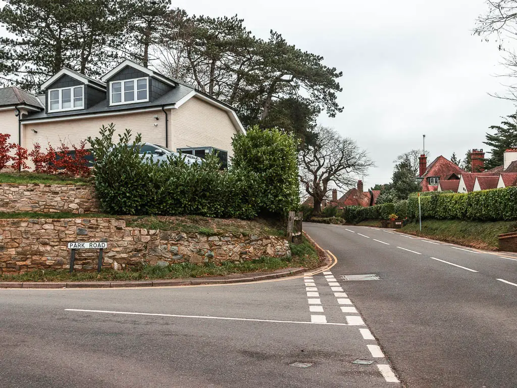 A road leading straight, and a road leading off it to the left, with a house on the corner. 