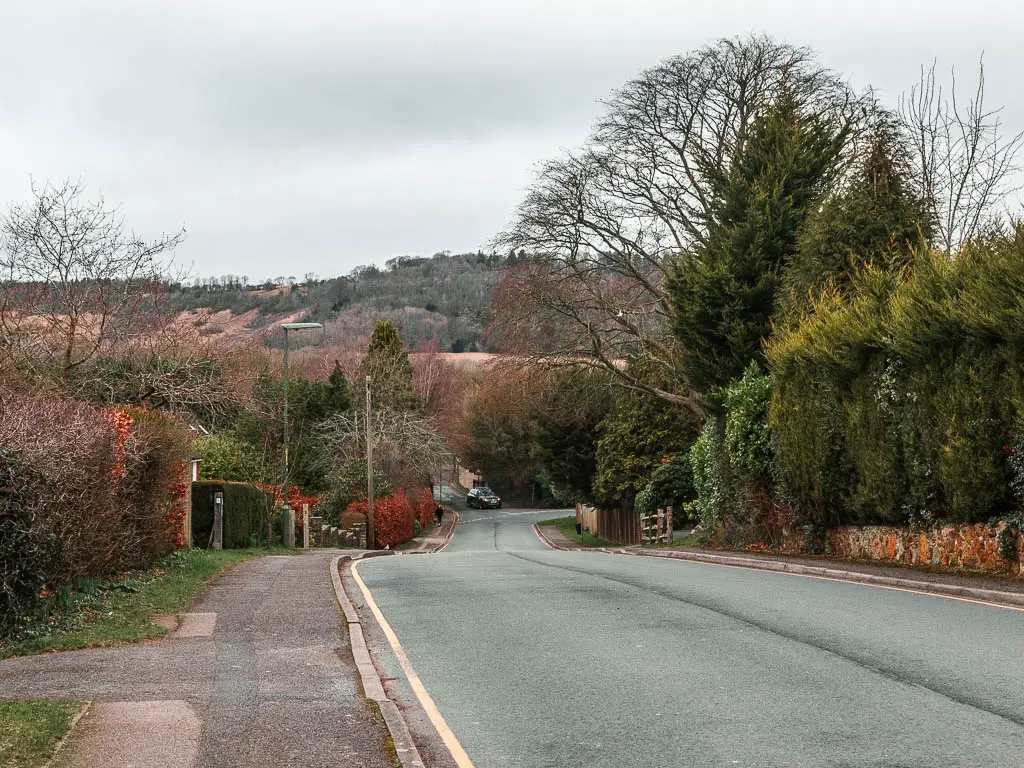 Looking down a road, lined with hedges and a view to the hills ahead, near the start of the walk toward Otford, out of Oxted.