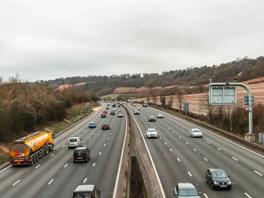 Looking along the M25, with lots of cars driving in both directions. 