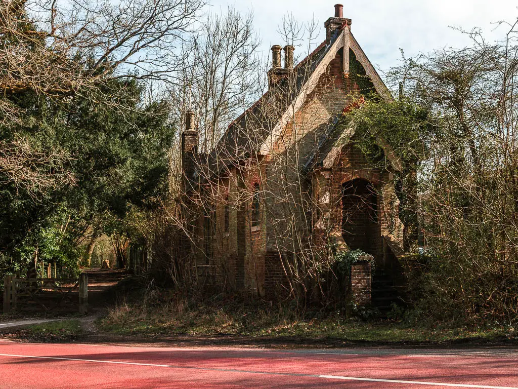 The old Rowfant railway station building partially engulfed by trees, next to the Worth Way Trail. 