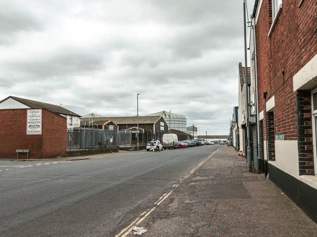 A wide road with factory buildings ahead to the left.