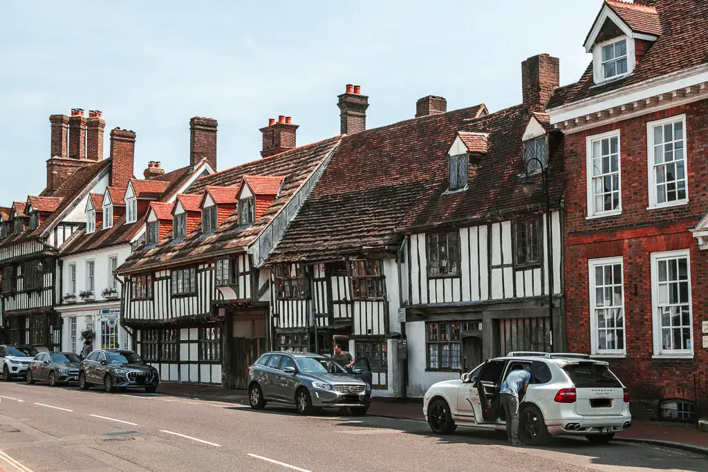 A row of Tudor buildings lining the street in East Grinstead at the start of the walk. There are cars parked on the street.