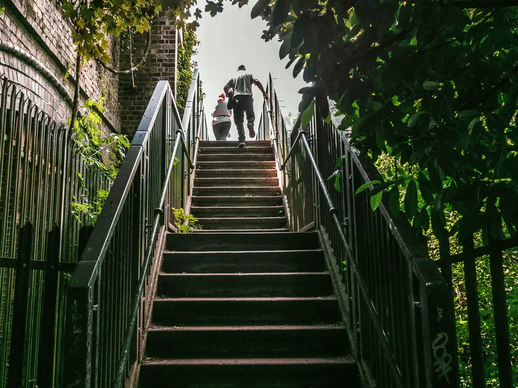 Steps leading up, with metal railings. There are two people at the top of the stairs.