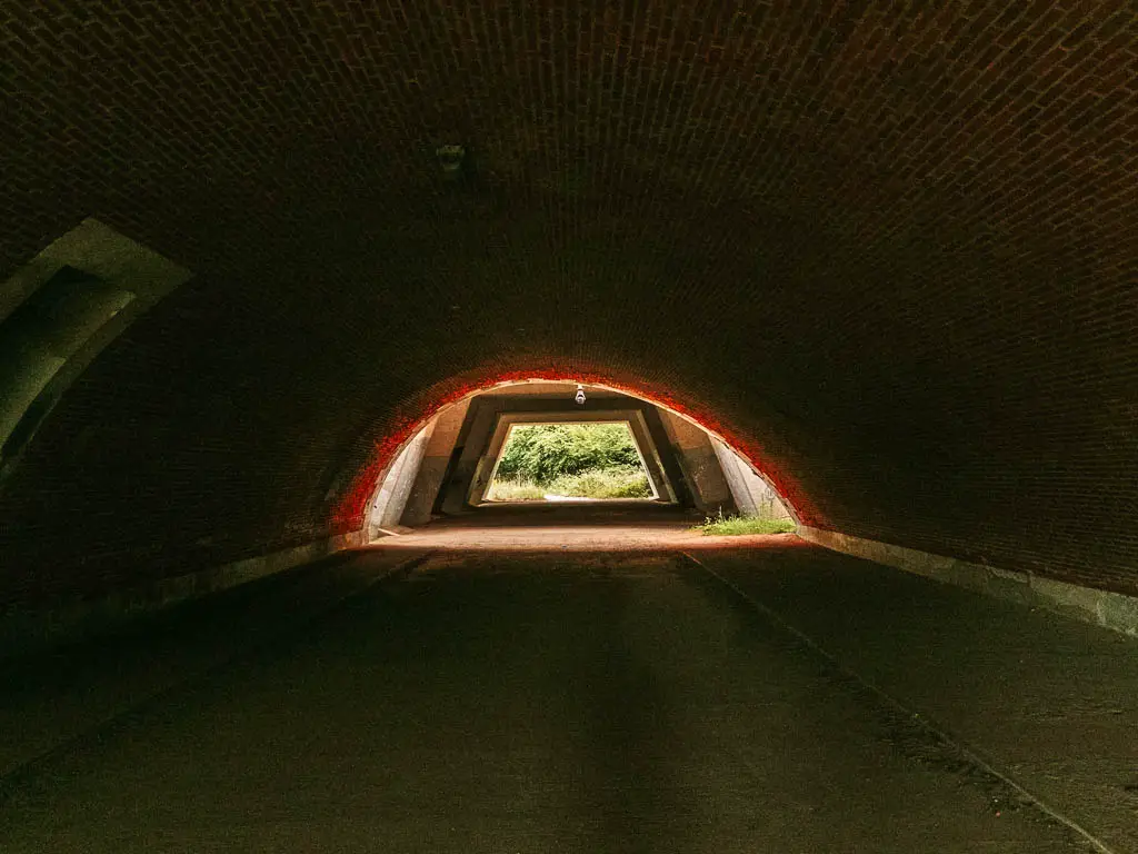 Looking through a dark tunnel with light at the end.