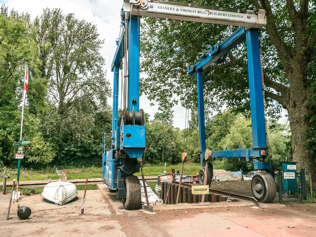 A tall blue metal structure next to the river. 