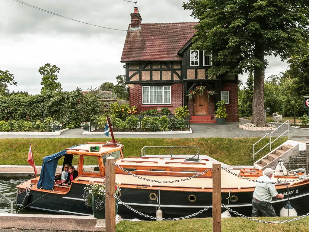 Looking over the boat in the lock to a cute lock house on the other side, on the walk from Maidenhead to Windsor.