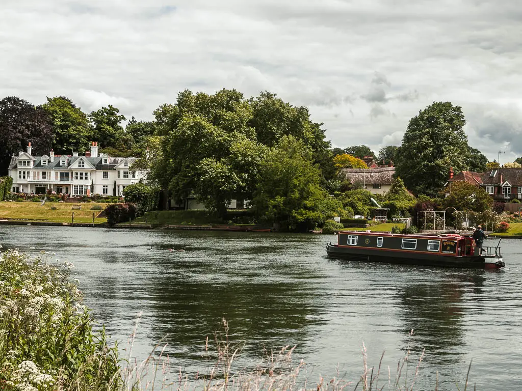 A barge on the river, with big trees and a grand white walled house on the other side, on the walk between Reading and Henley.