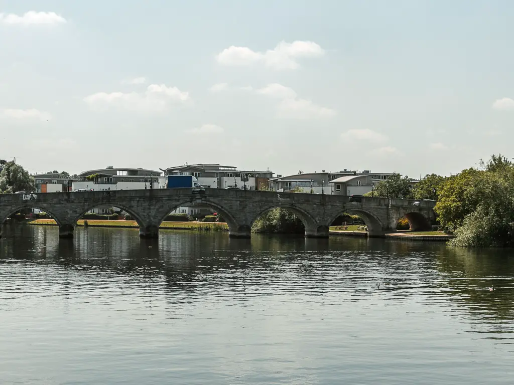 Looking along the river to an archway bridge crossing it. 