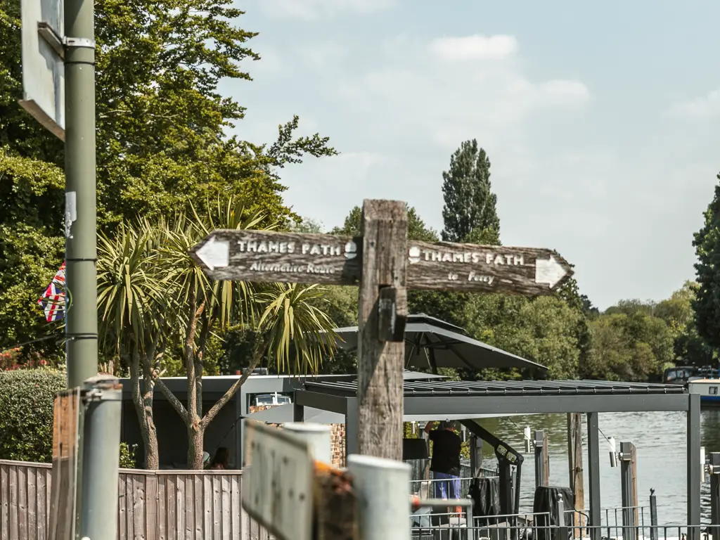 A wooden thames path sign pointing left and right.