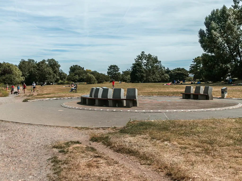 A circle with stone benches in the field.