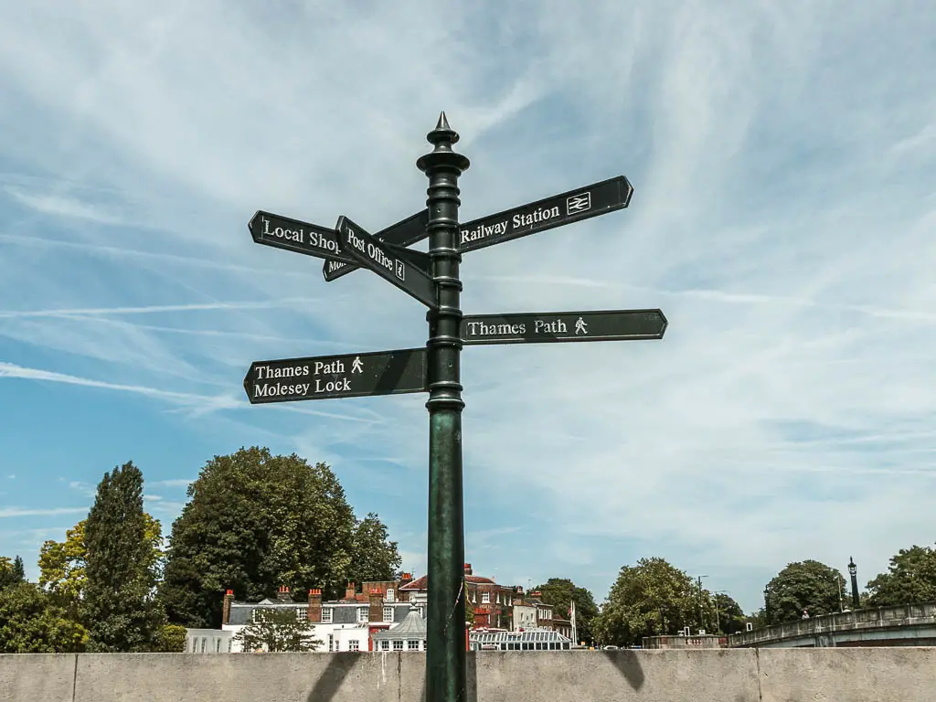 A signpost pointing in lots of directions with a backdrop of blue sky.