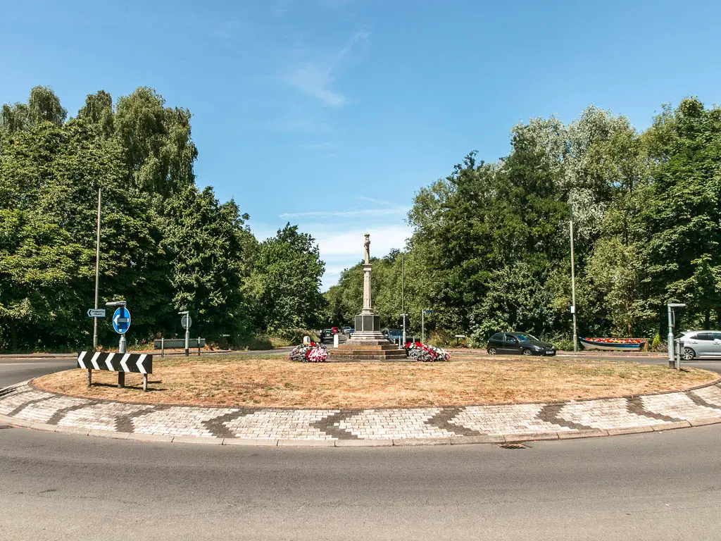 A big roundabout with grass and monument in the middle.