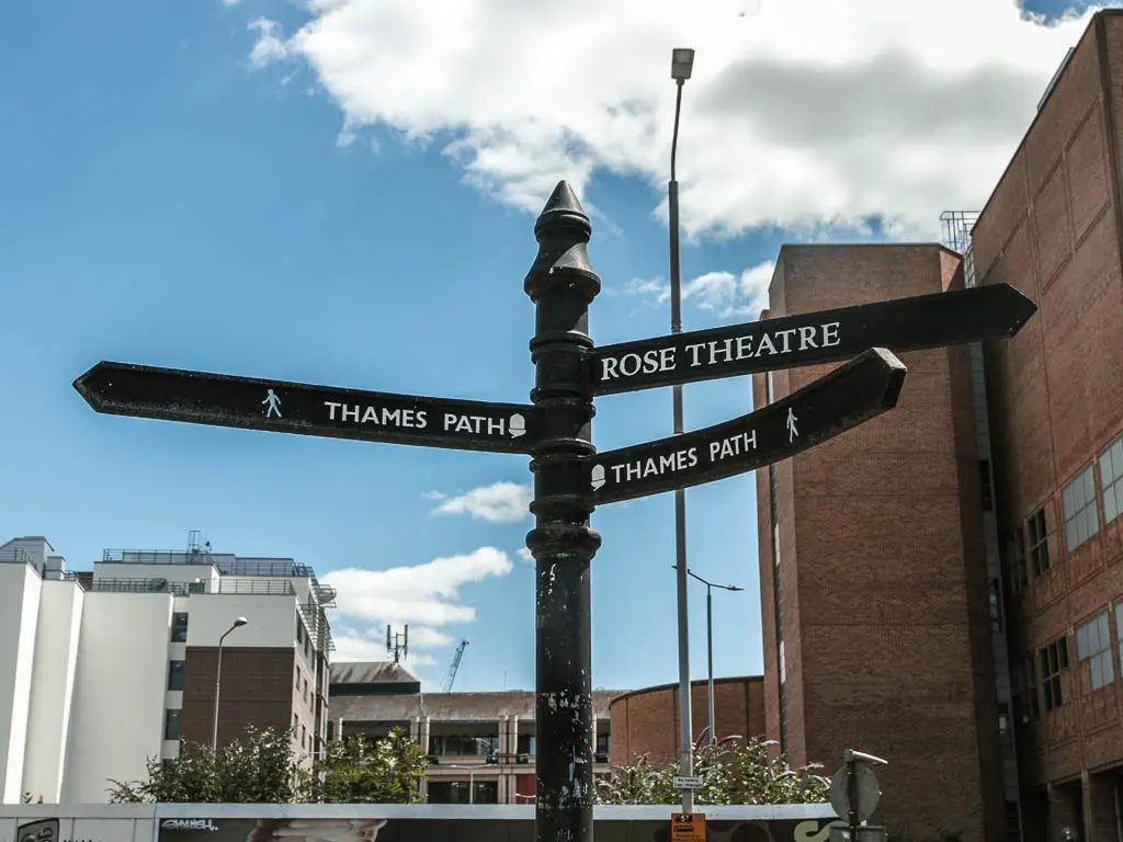 A black trail sign pointing left and right for the Thames Path.