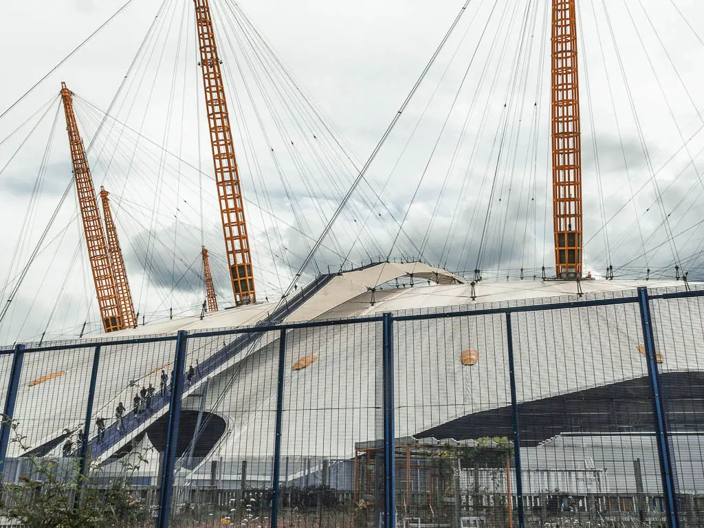 The 02 building behind a blue metal fence.