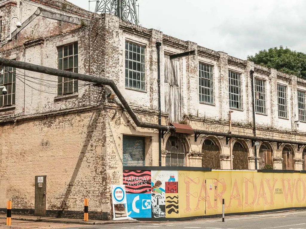 An old derelict factory buildings with peeling white paint, on the walk from Tower Bridge to the Thames Barrier.