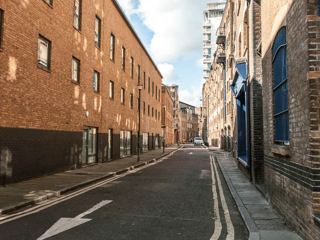 Looking along a road lined with brick buildings.