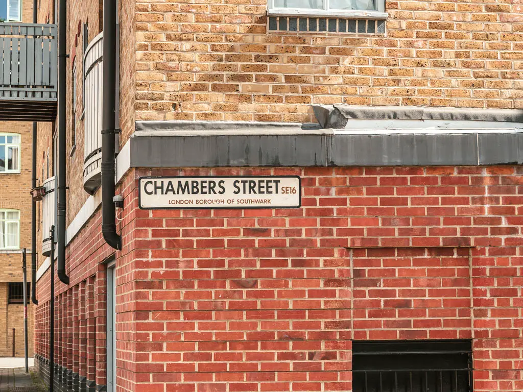 A road sign saying 'Chambers Street' on a red brick wall.