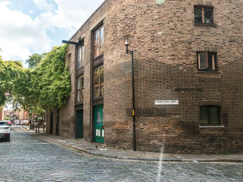 Looking to the corner of a brick bridling on a cobbled street.