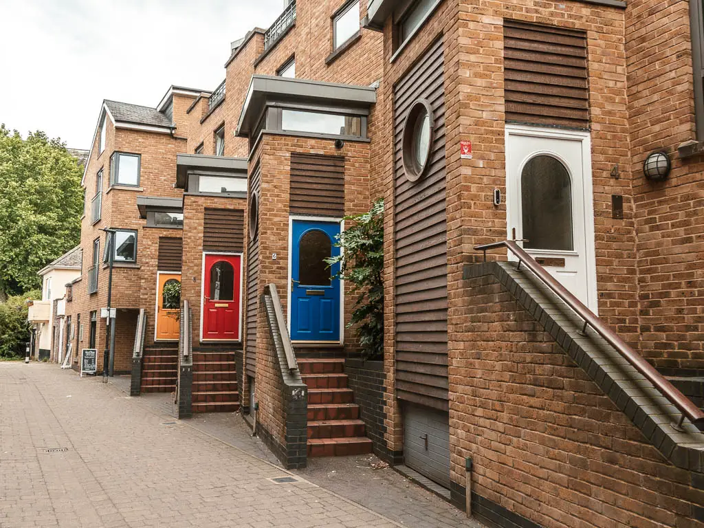 A row of houses with steps leading up to each one with a colourful door in Greenwich.